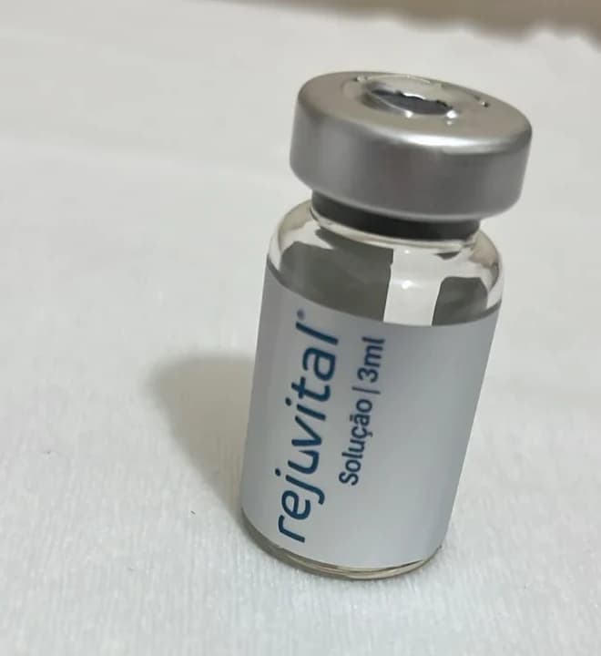 Frasco de 3 ml da solução Rejuvital sobre uma bancada coberta com papel branco